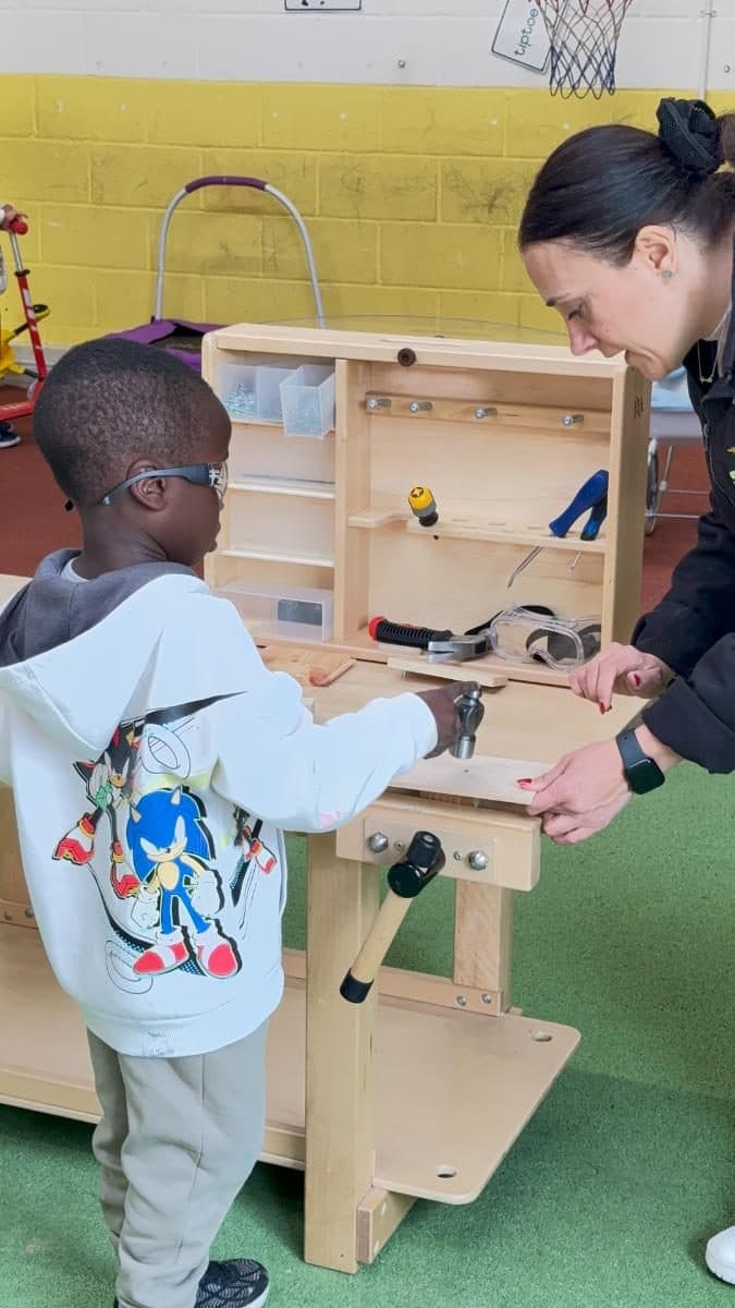 destiny haven nursery child uses a wooden tool workbench with various tools