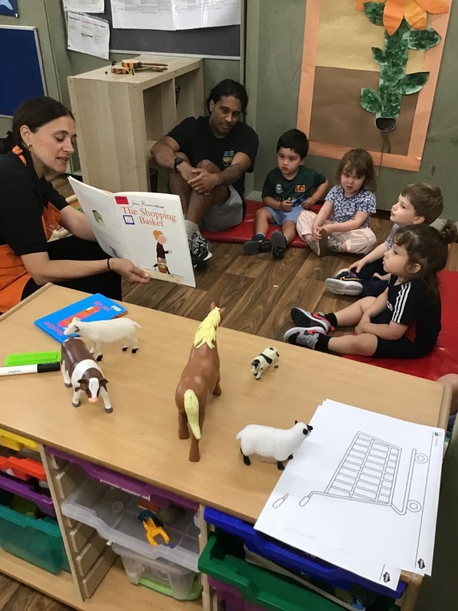practitioners reading to children with toy animals